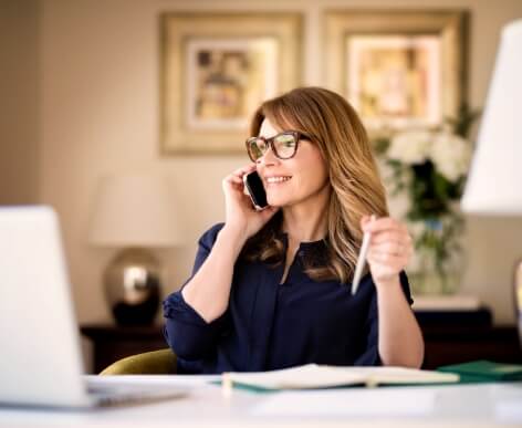 A woman on the phone at her desk